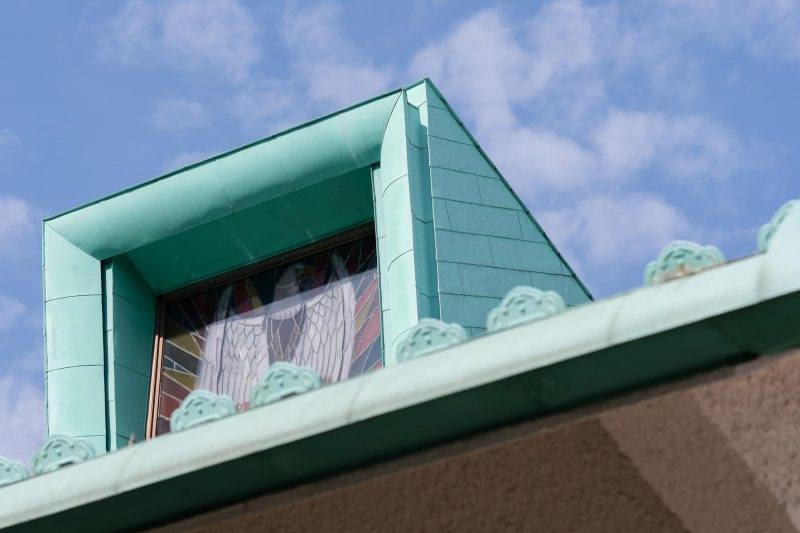 屋根のてっぺんにそびえ立つオジロワシのステンドグラス